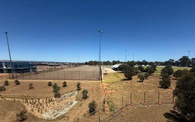 Nearby public reserve with fenced sports courts and open space