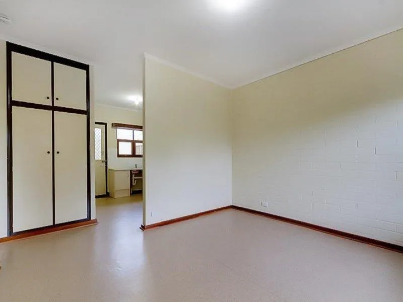 Bedroom with a floor-to-ceiling built-in robe, looking through to the kitchen